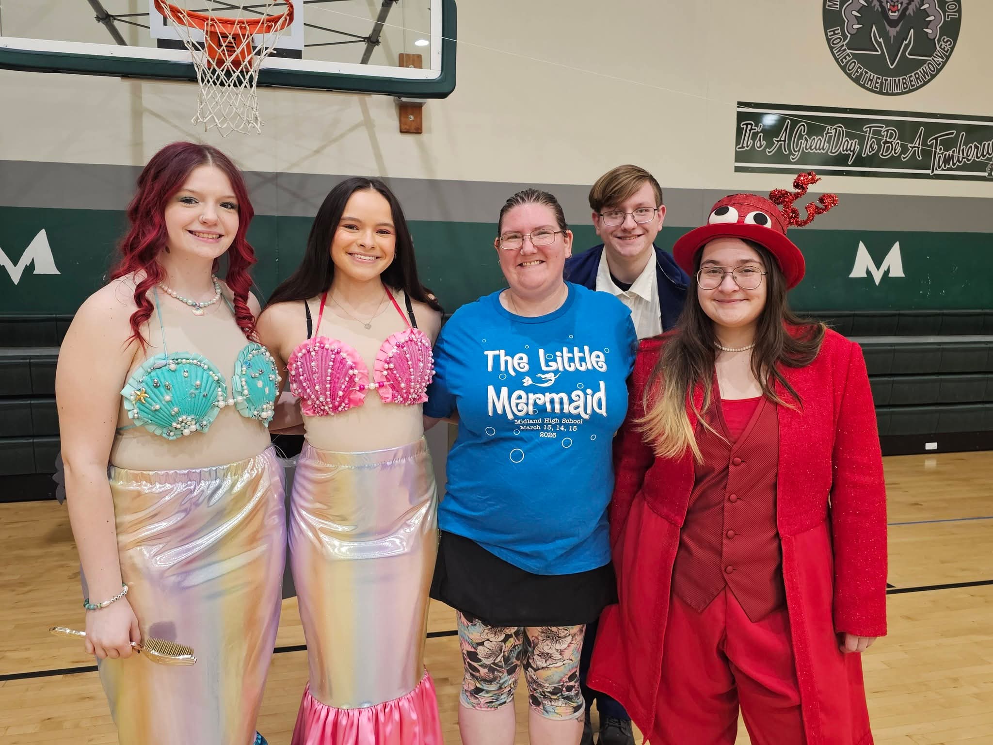 Little Mermaid cast members in costume with event organizer